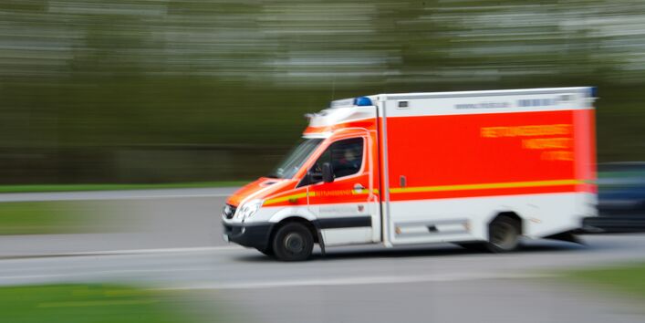 Ein Bild zeigt einen fahrenden Krankenwagen.