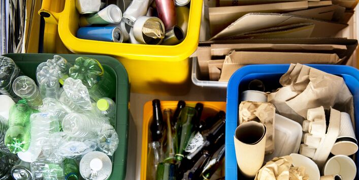 Verpackungsabfälle in vier verschiedenen Abschnitten: Papier, Plastik, Glas, Konserven 