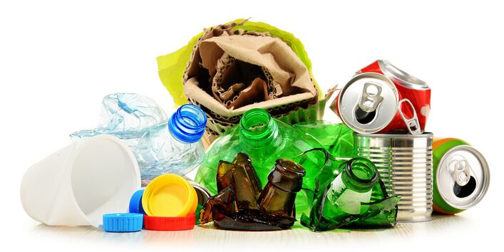 The photo shows packaging waste: Cans, bottles, paper. 