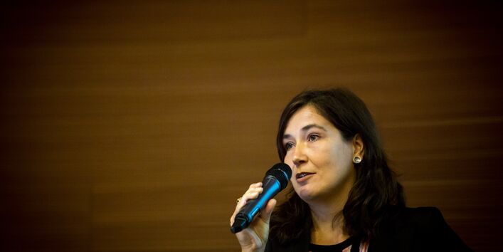 Moderatorin spricht auf dem Podium ins Handmikro