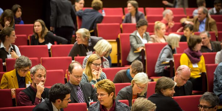 Teilnehmer sitzen im Hörsaal und diskutieren
