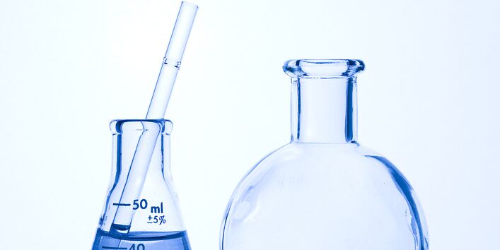 Zwei unterschiedliche Reagenzgläser, mit Flüssigkeit gefüllt, stehen nebeneinander.