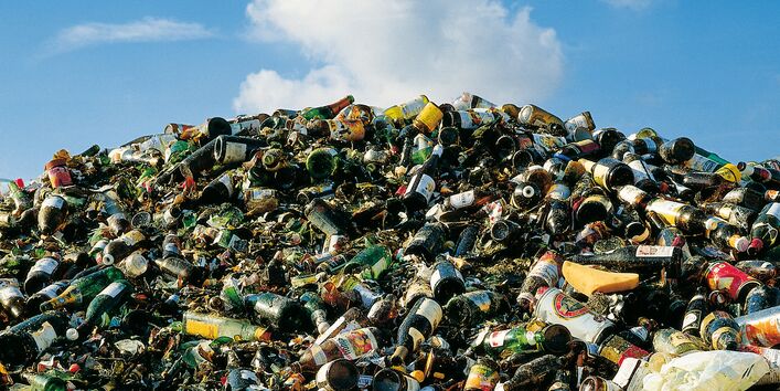 Müllhalde mit Glasflaschen und Getränkedosen
