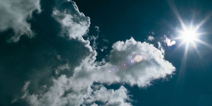 Blauer Himmel mit Sonne und Wolken