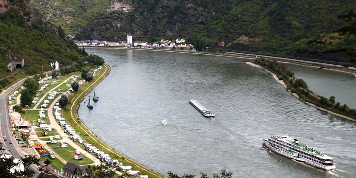 Rheintal: auf dem Wasser ein Ausflugsdampfer und ein Transportschiff