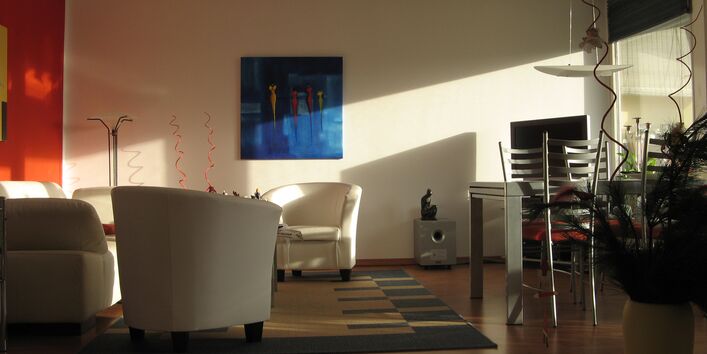 livingroom with armchairs, dining table, carpet, lamps, pictures and potted plants