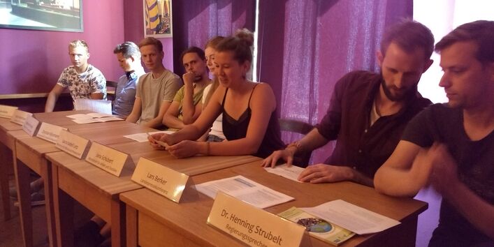 Das Bild zeigt eine gespielte Pressekonferenz mit Vorstellung der Regierungsprogramme im Rayonhaus