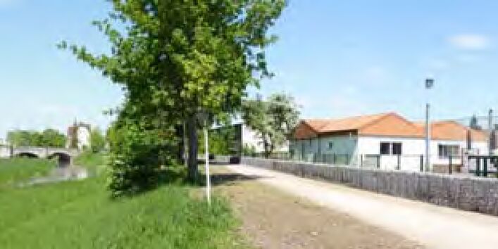 Eine Steinmauer steht schützend vor Häusern