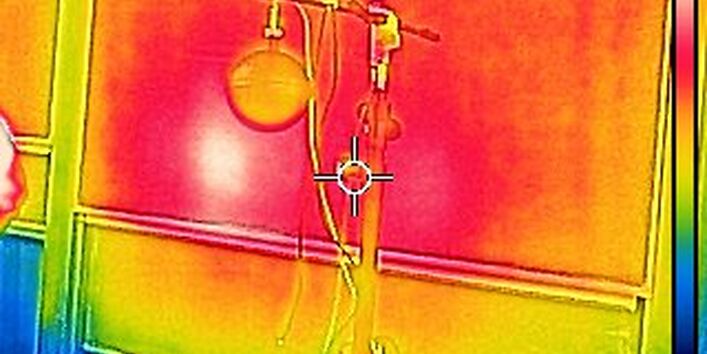 Wärmebildaufnahme, vermutlich ist eine Tafel und ein Messgerät zu erkennen, beide durch Farben als Warm gekennzeichnet.