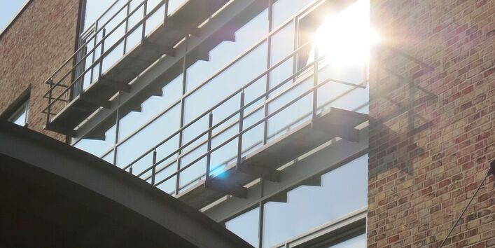 Ein Gebäude mit großen Fensterfronten mit schmalen Balkonen