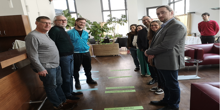 Gruppenbild der Projektbeschäftigten. Sie stehen gereiht und sortiert nach Projektabschnitten.