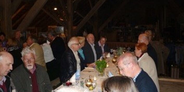 Menschen sitzen im Kunstzentrum an einer langen Tafel und essen Produkte aus der Region.