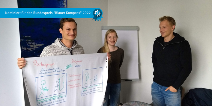 Das Bild zeigt drei Studierende mit Entwurf Poster. Präsentation der Gruppenarbeit im Workshop Klimawandel und Gesundheit im Ministerium für Arbeit, Soziales und Integration.