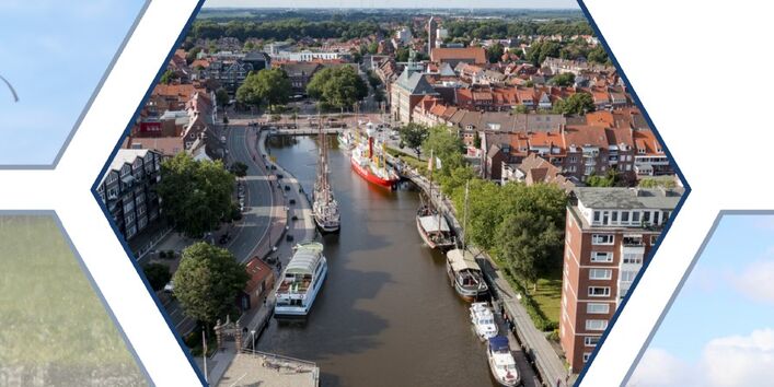 Der Blick trifft aus der Höhe auf einen Fluss, der durch eine Stadt fließt.