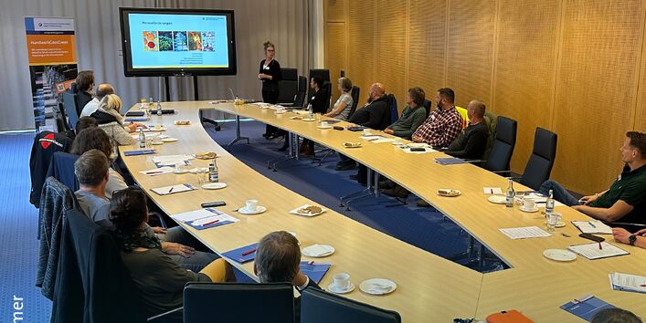 Veranstaltung  zum Thema klimaangepasstes Bauen mit Handwerksbetrieben. Teilnehmende sitzen am Konferenztisch. am