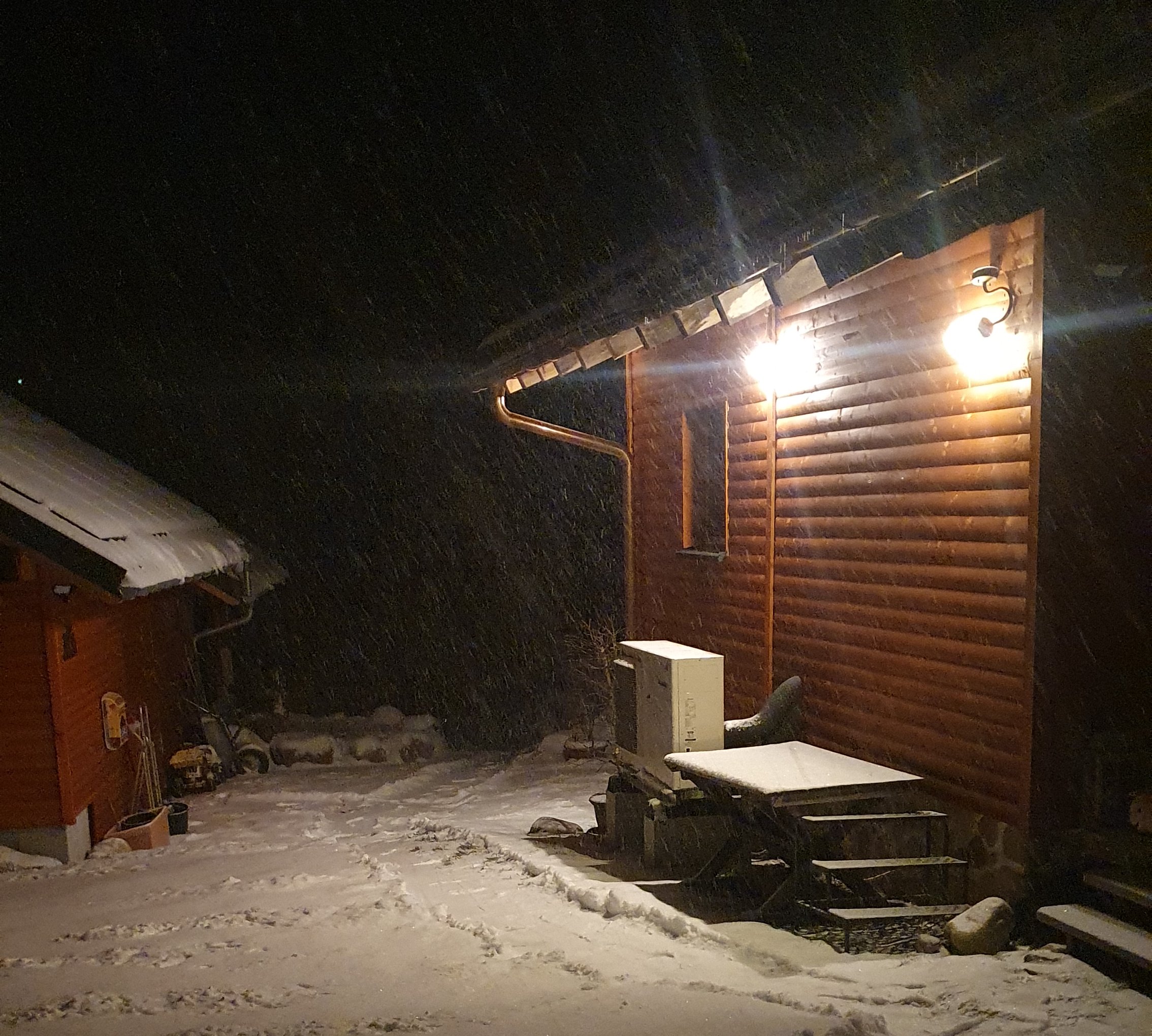 Monoblock Wärmepumpe steht geschützt unter Dachvorstand, sonst alles verschneit.