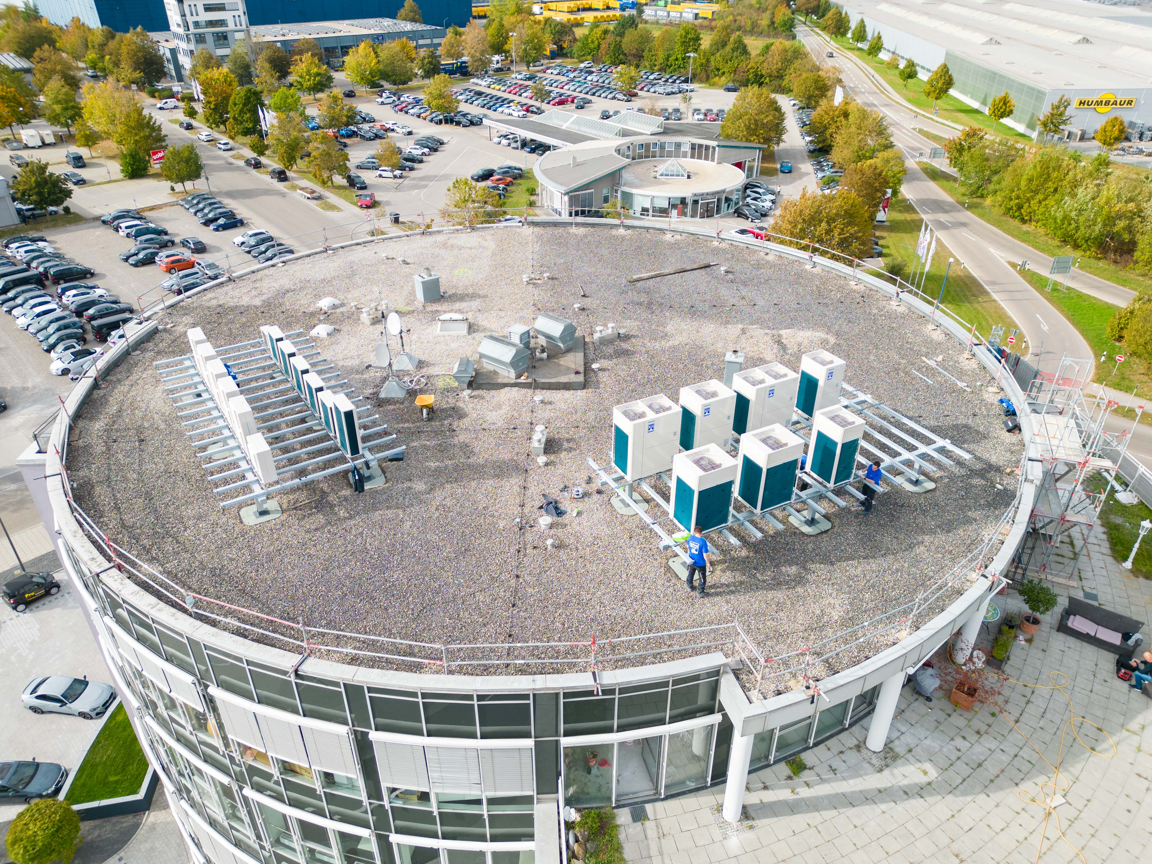 Die Außengeräte der Luft-Luft-Wärmepumpen auf dem Kiesdach des Bürogebäudes