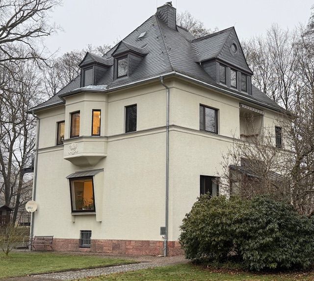 Ein beiges 3-Familienhaus mit Schieferdach und Sockel aus rotem Sandstein.