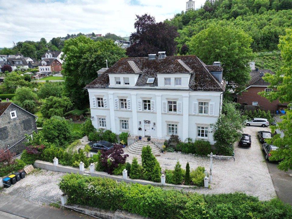 Eine Luftaufnahme einer denkmalgeschützten Villa mit zwei Geschossen.