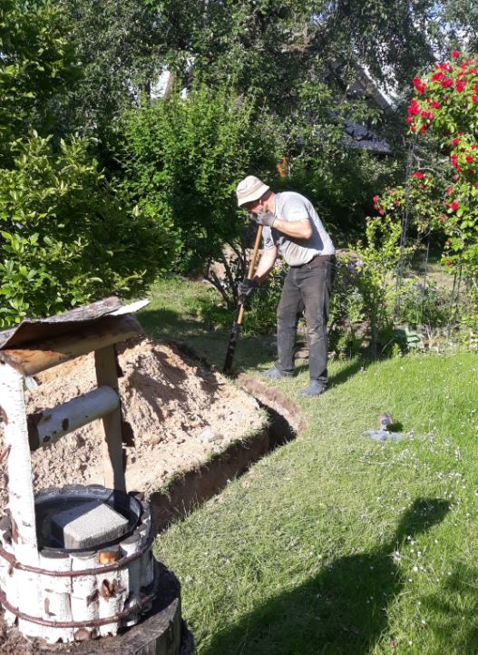 Ein Mann arbeitet am Grabenaushub für Erdwärme-Flachkollektor.
