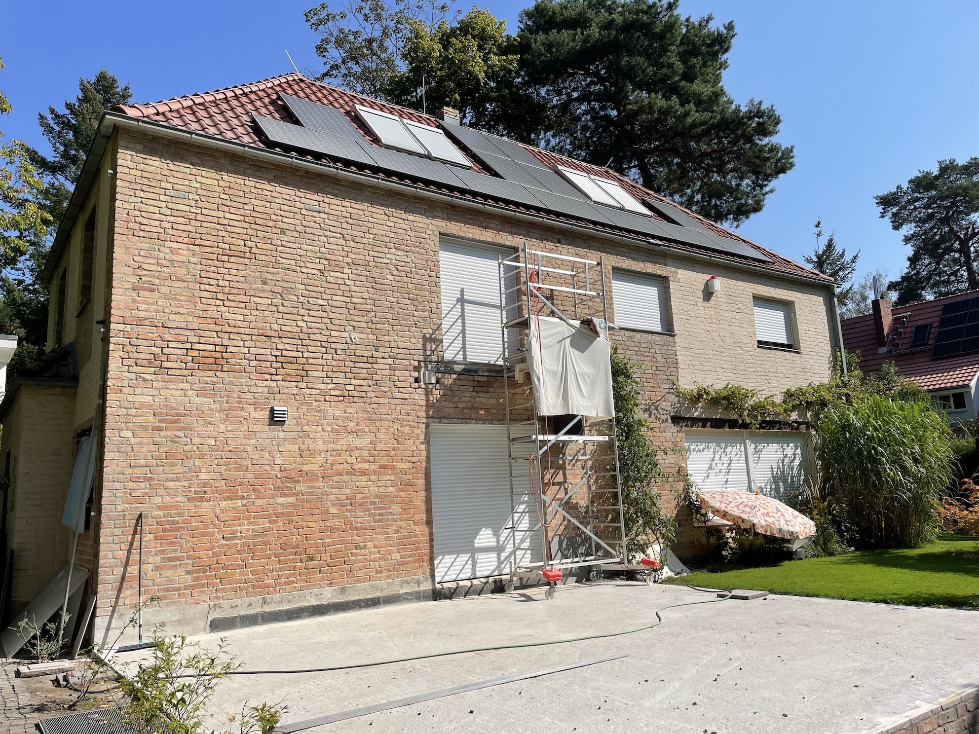 Ansicht des zweistöckigen Hauses von der Straße her. Auf dem Dach sind Photovoltaik-Module zu sehen.