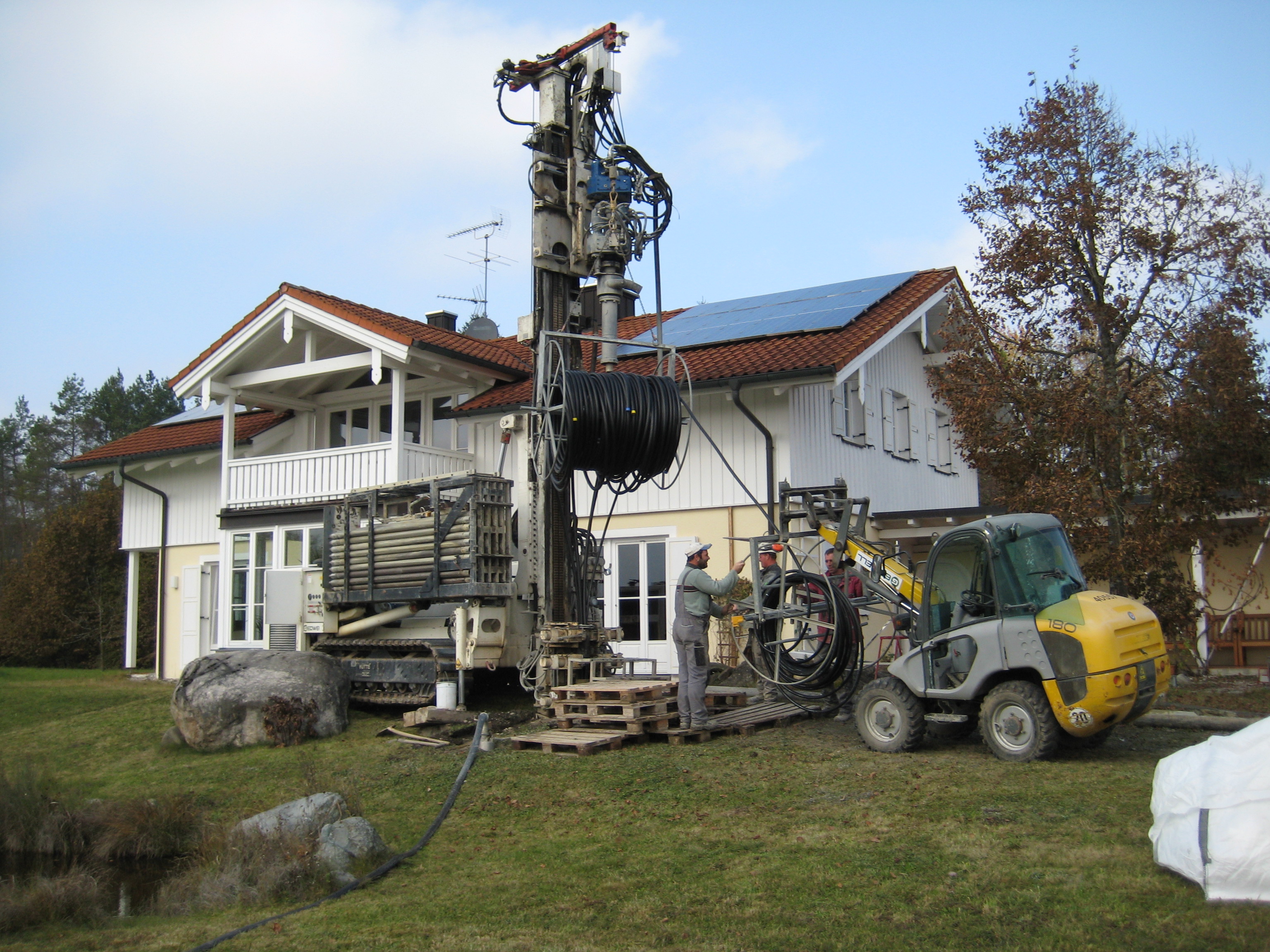 Ein Bohrgerät vor dem freistehenden Einfamilienhaus