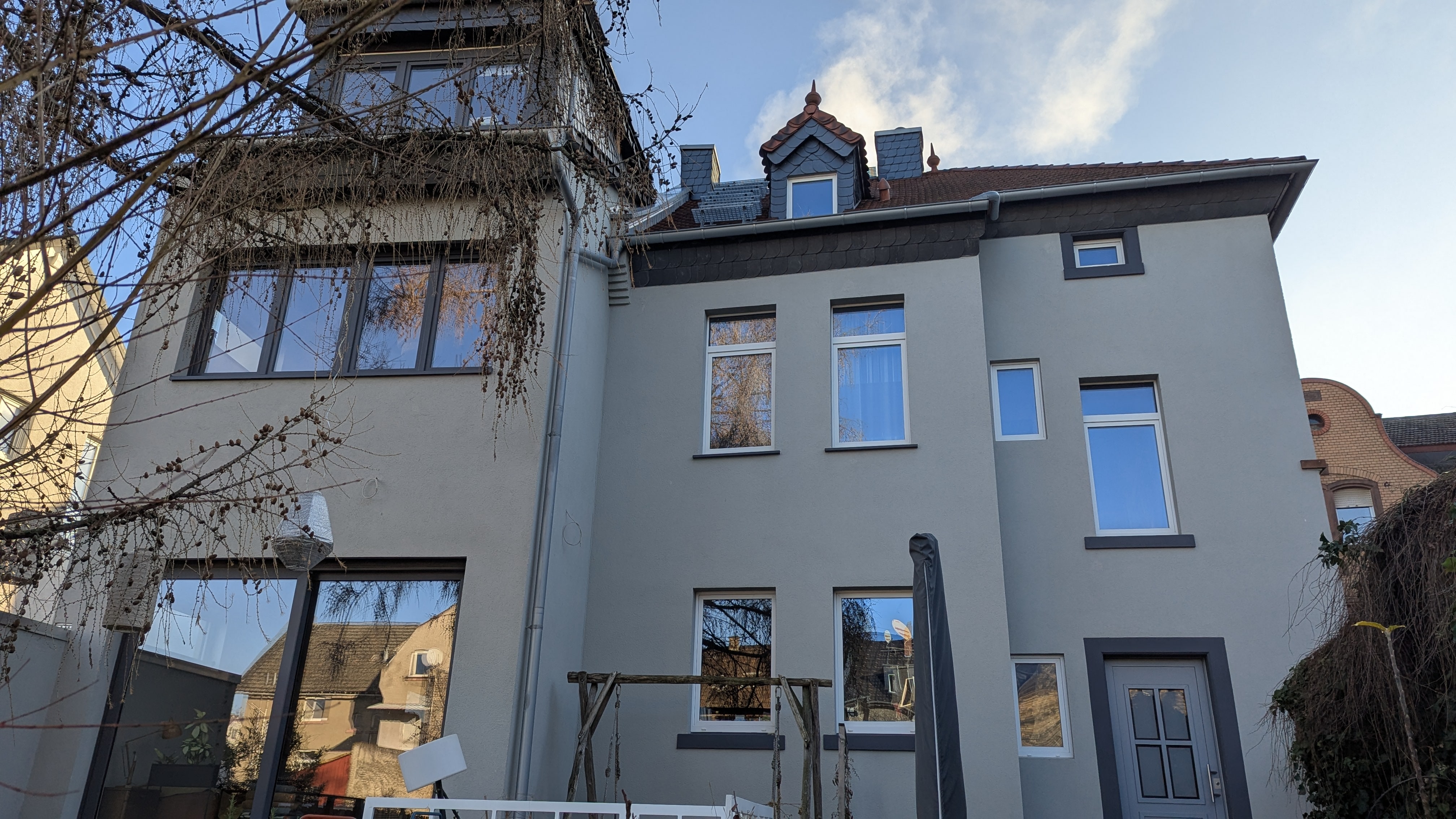 Die Rückseite eines Altbaus mit modernem Anbau.