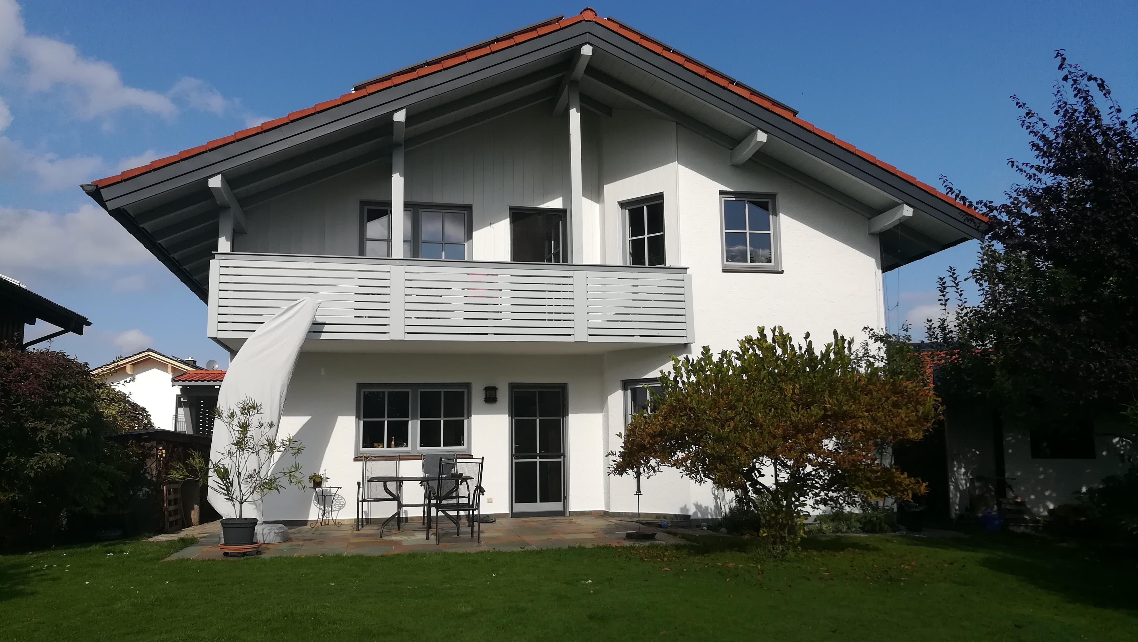 Ein weißes Einfamilienhaus mit Garten.